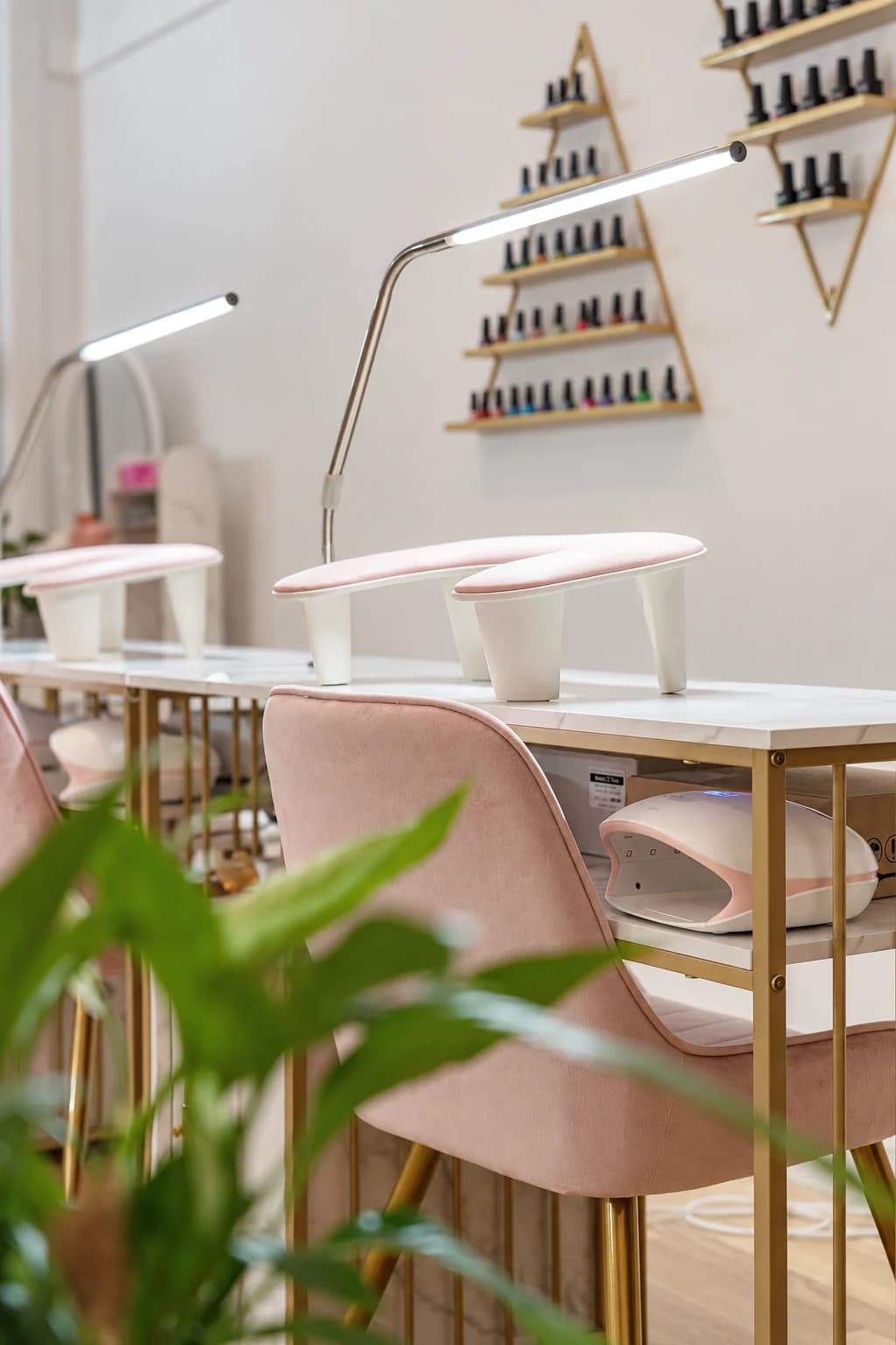 Nailtechs manicurepladser med rosa stole og messingdetaljer